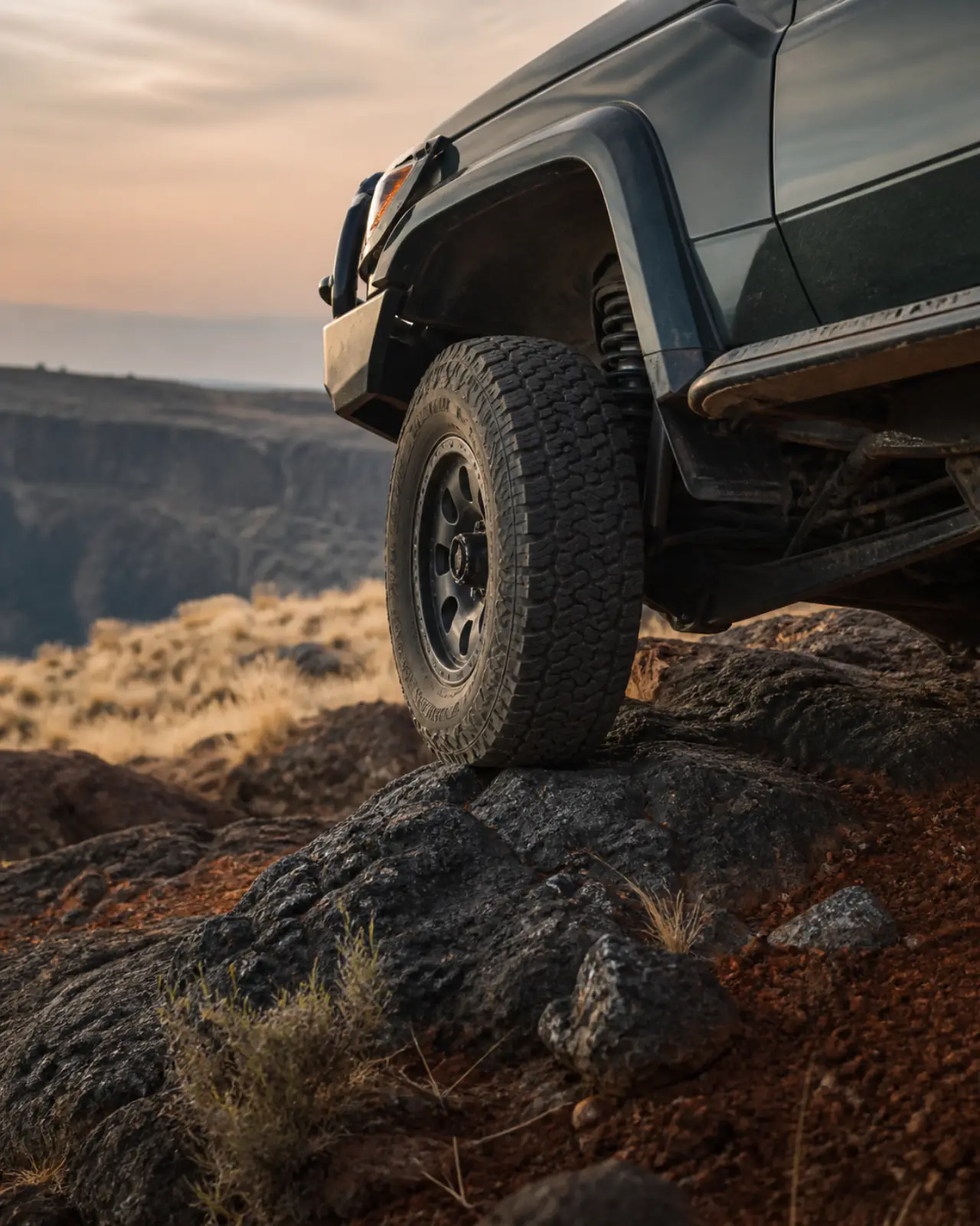 An off-road tyre crossing dark volcanic rock